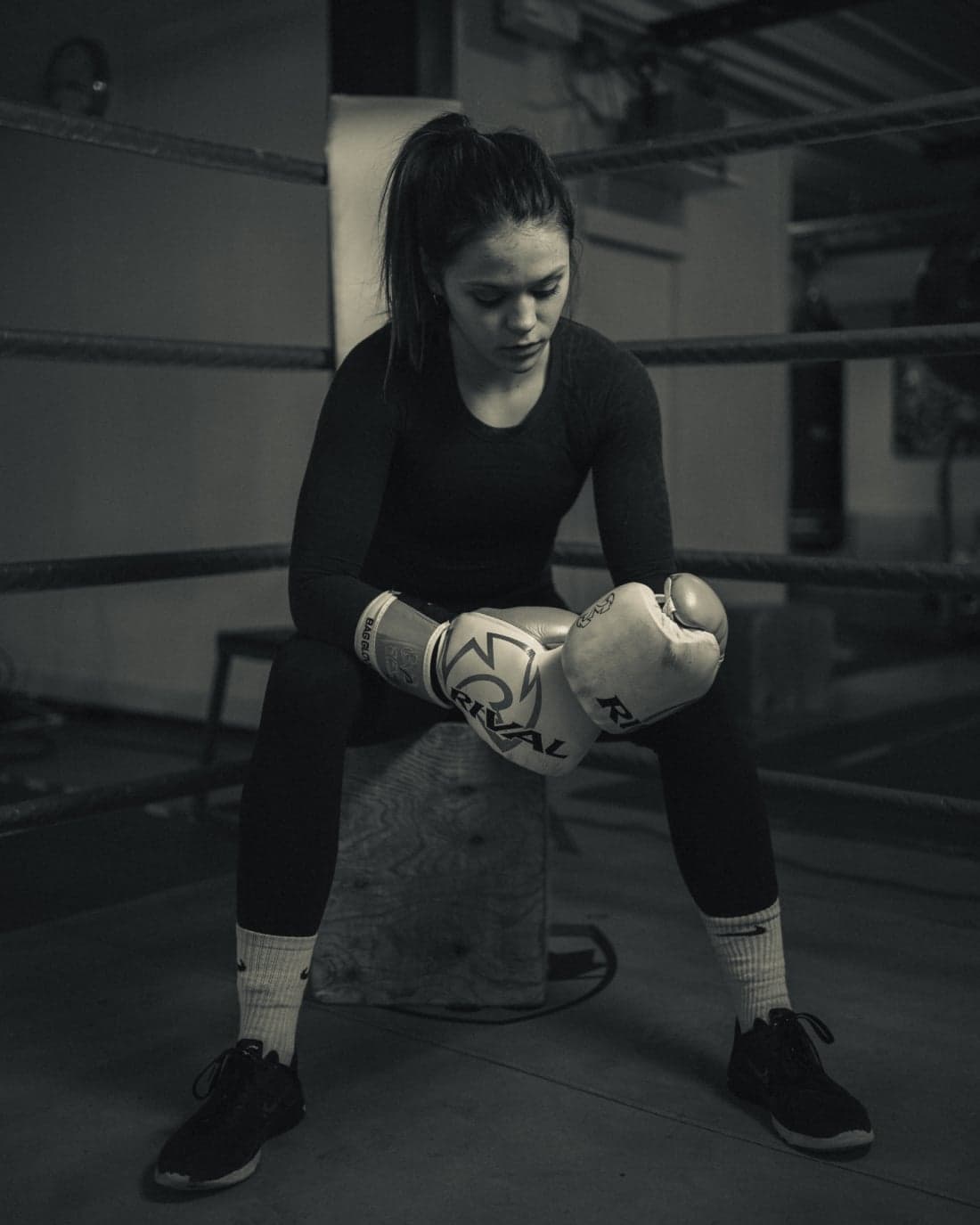 Head coach Emelia Dermott-Goodin seated ringside wearing boxing gloves